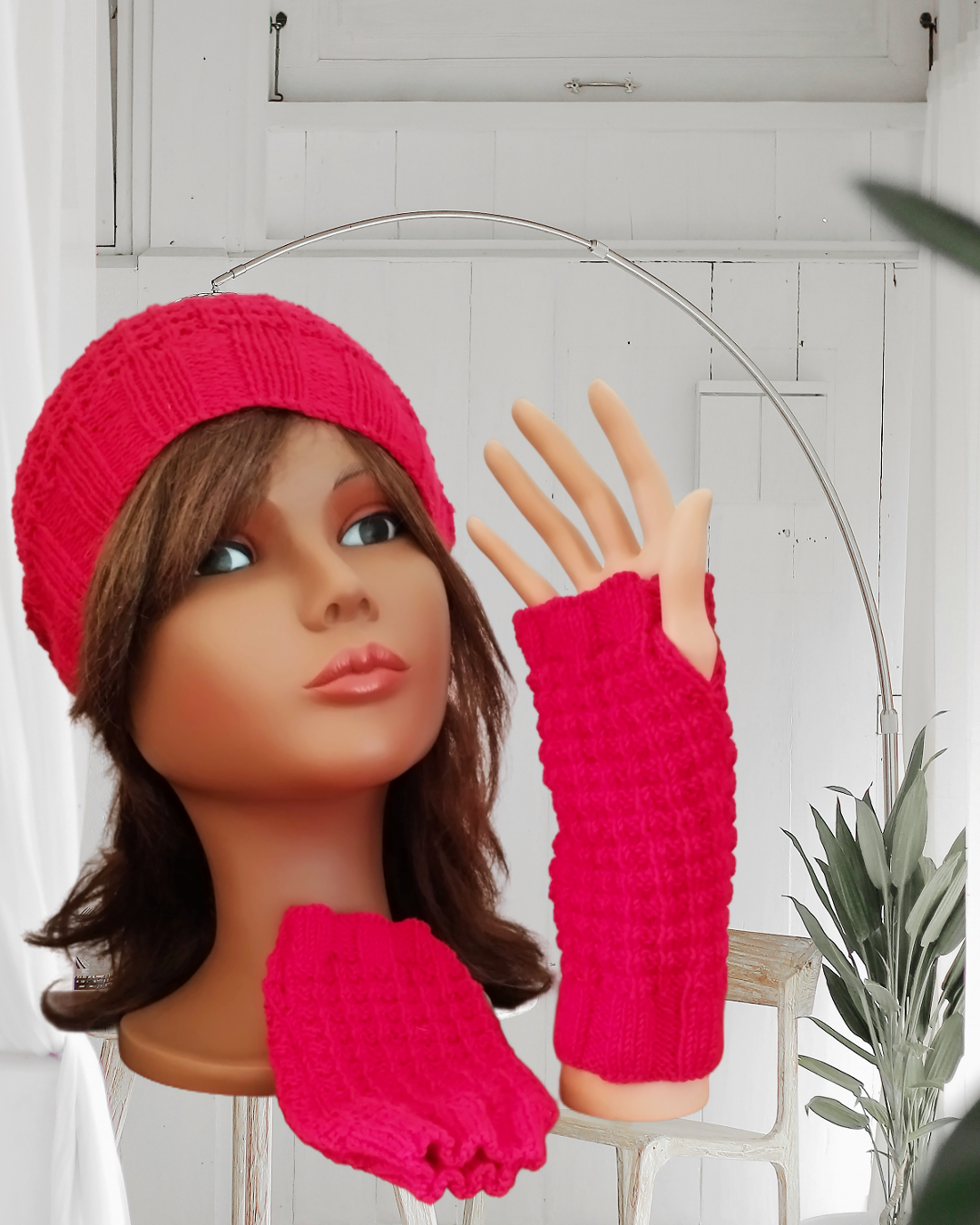 Mannequin de vitrine présentant des mitaines en laine rouge.
