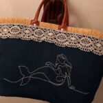 Panier artisanal en jean avec broderie de sirène et bordure en dentelle.